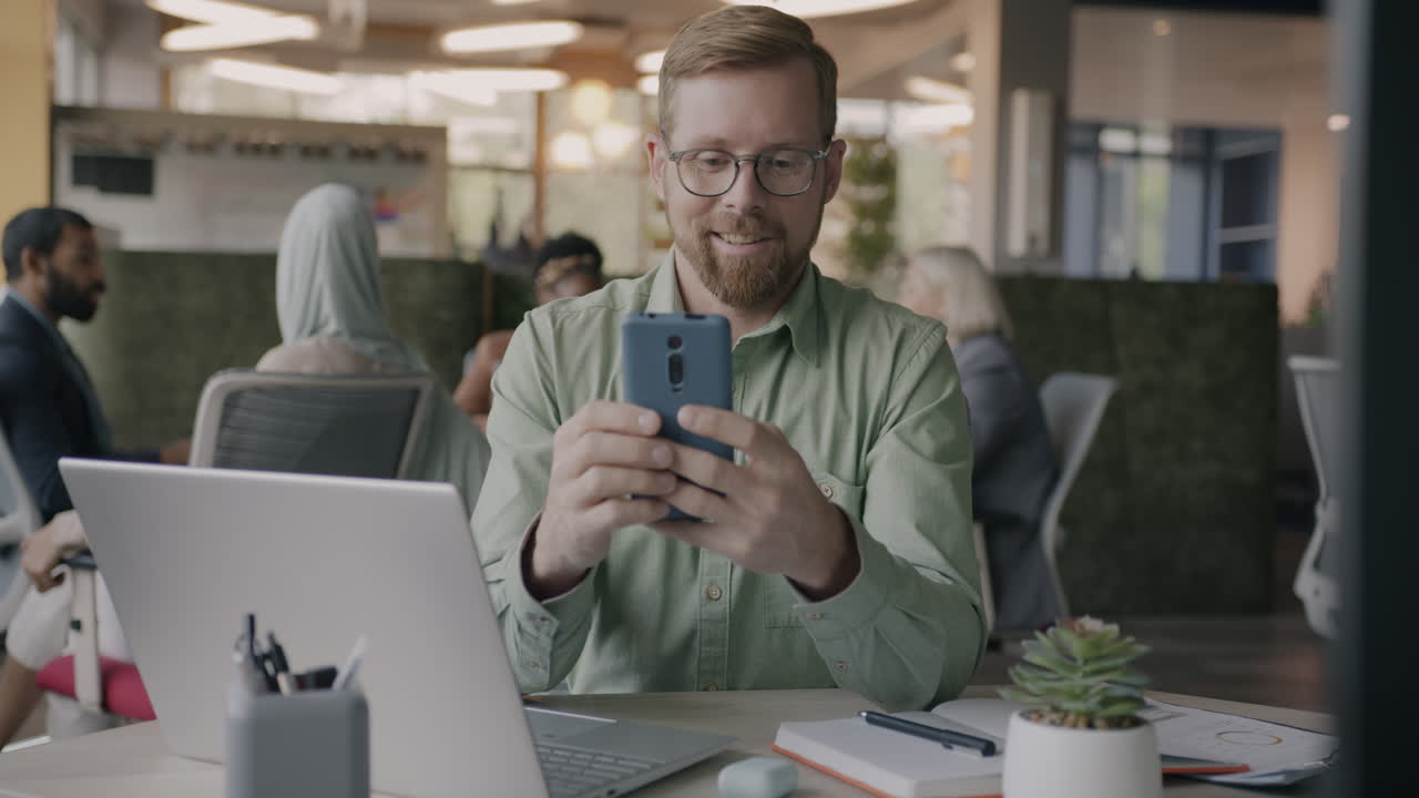 Businessman Looking at Smartphone in Office