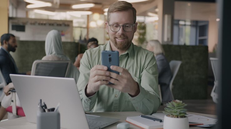 Businessman Looking at Smartphone in Office