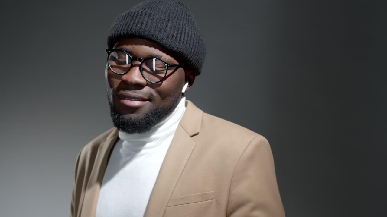 hombre afroamericano con estilo disfrutando de la música en el teléfono inteligente