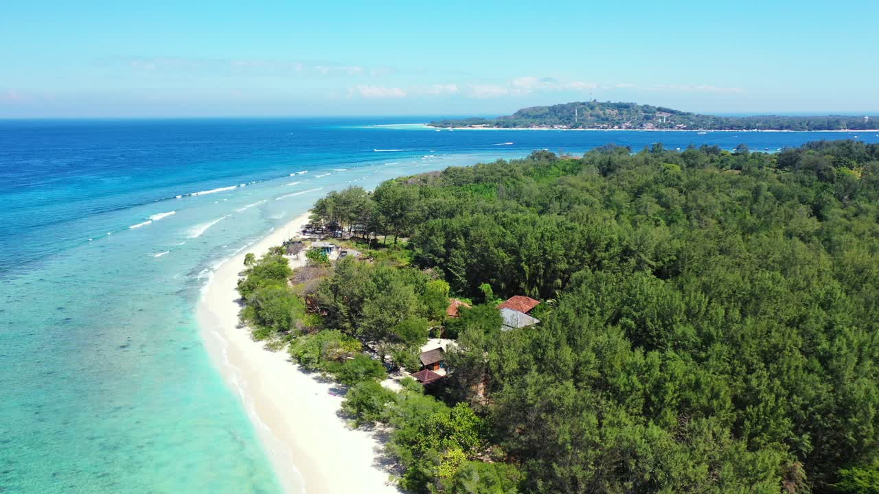 Bright sunrise on tropical island of Bali, with lush vegetation and pine trees forest, white beach surrounded by blue turquoise sea