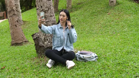 girl sitting on grass and selfie , video in 4k
