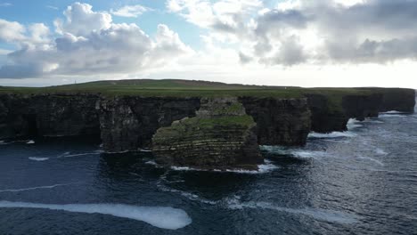 Majestuosos-Acantilados-De-Kilkee-En-Irlanda-Con-Olas-Y-Exuberante-Vegetación,-Vista-Aérea