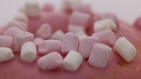 appetizing sweet donut dessert in pink glaze close-up rotates. light sweet breakfast donut close-up. colorful dessert snack pastries. selective focus, shallow depth of field