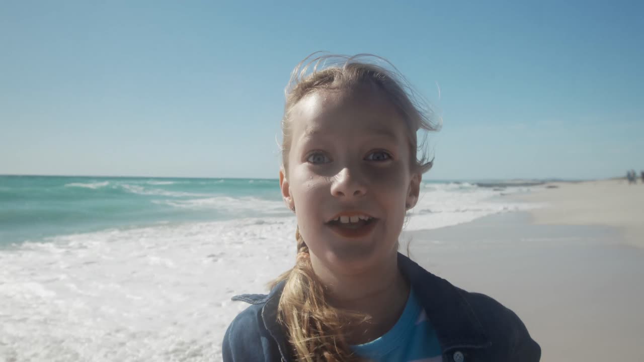 해변에서 웃긴 얼굴을 하는 어린 소녀