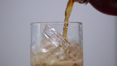 watch as a refreshing drink is expertly poured over ice showcasing liquid movement