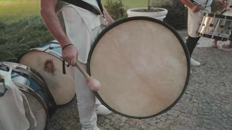 Geleneksel açık hava performansında büyük davullara vuran müzisyenler