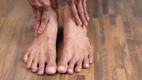 elderly person massaging their feet