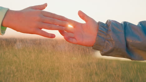 children interlock fingers under rain closeup sister and brother bond grows stronger united by