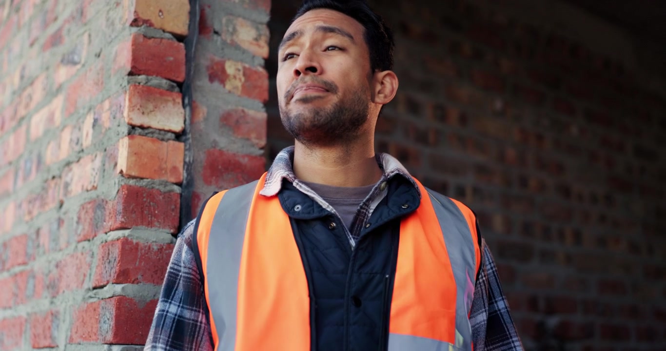 Stressed Construction Worker Removing Hard Hat at Building Site