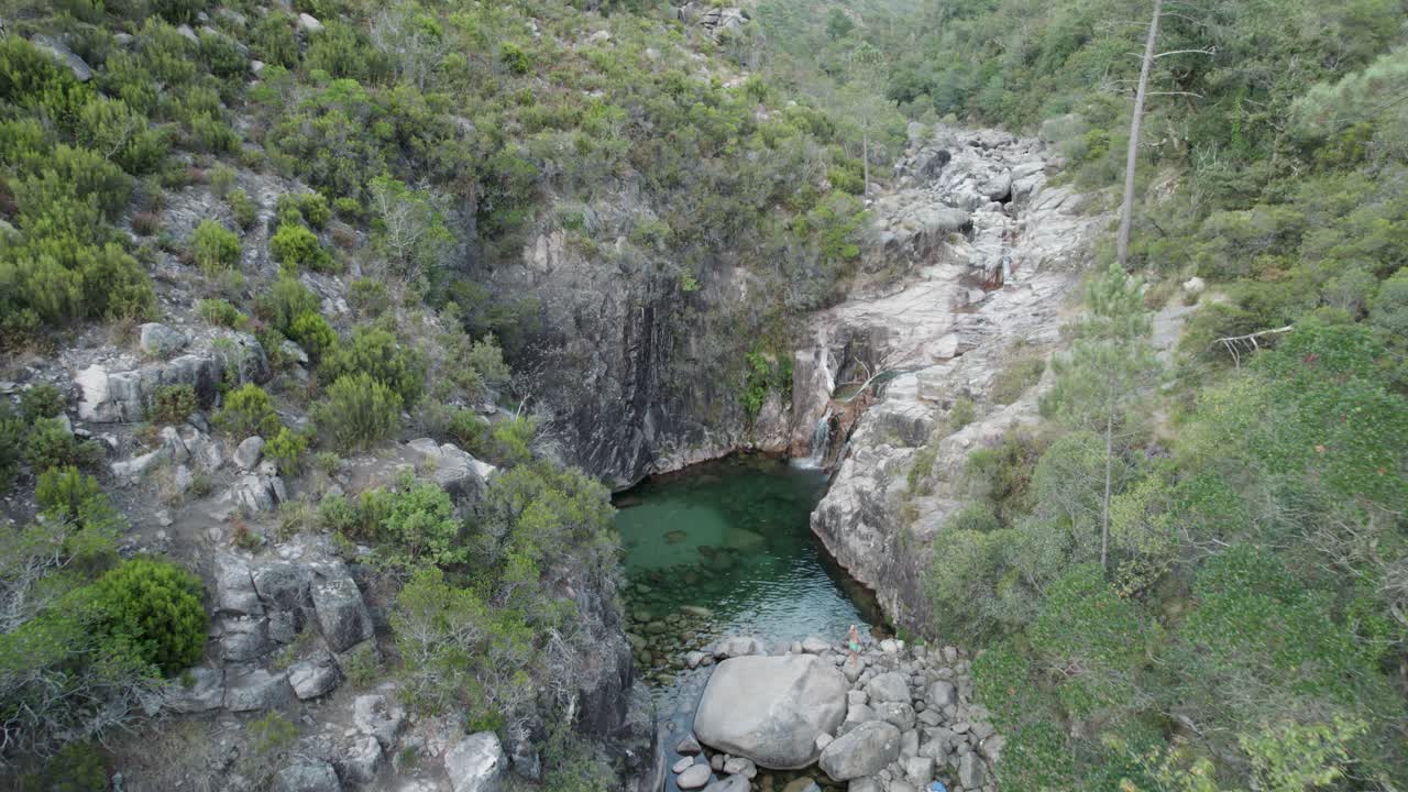 vuelo aéreo hacia la cascada portela do homem, corriente de agua dulce sobre rocas, inclinación hacia abajo