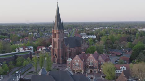 Church-in-the-middle-of-a-city-in-the-north-of-Germany-during-sunset-drone-flight