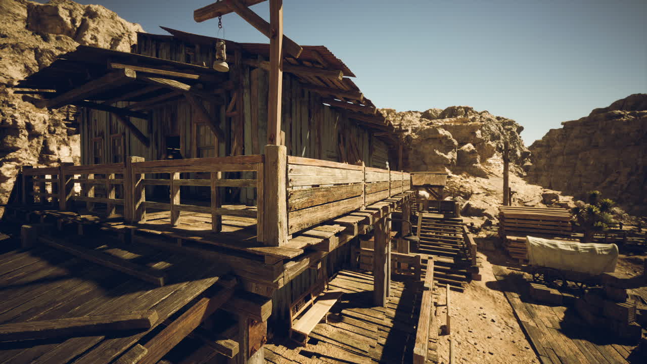 A rustic wooden structure set against rocky hills in a desert landscape