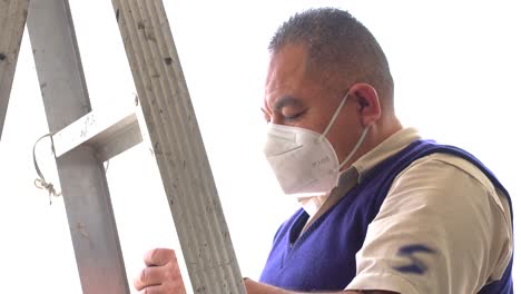 Latin-man-standing-in-ladder