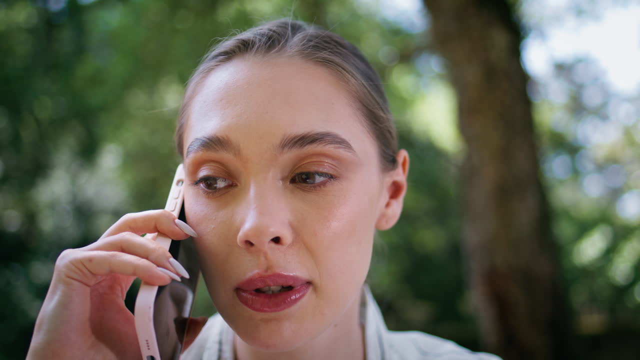 Portrait girl dissatisfied phone call standing in park. Woman smartphone talk