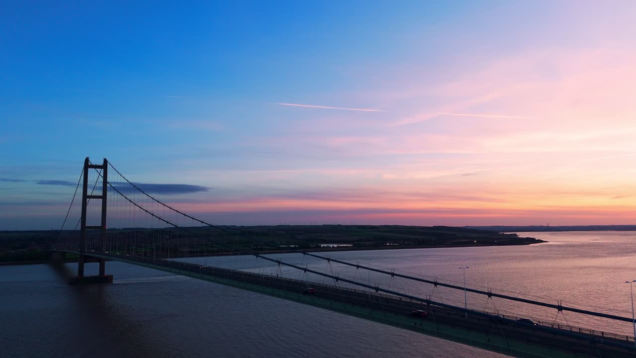 Sunset's charm: Aerial view of Humber Bridge with cars in motion