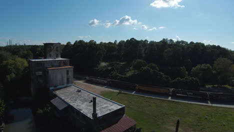 Vuelo-De-Drones-Fpv-Alrededor-De-Un-Edificio-Abandonado-Y-Crucero-A-Lo-Largo-De-Una-Cascada-Con-Nadadores-Cercanos-En-Un-Día-Soleado