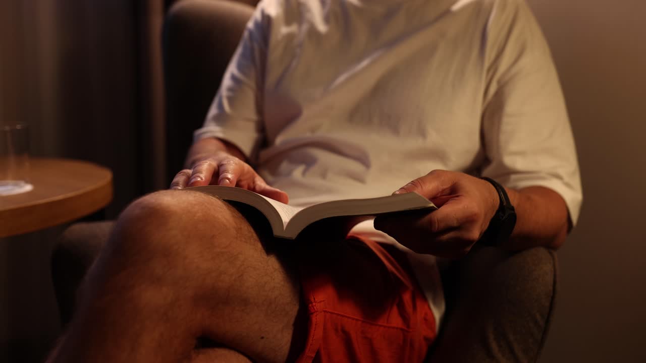Uomo che legge un libro su una poltrona
