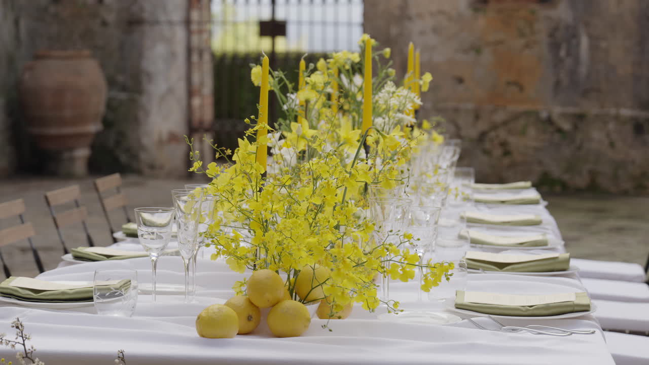 Elegant Outdoor Dining Table Setting with Yellow Flowers and Lemons