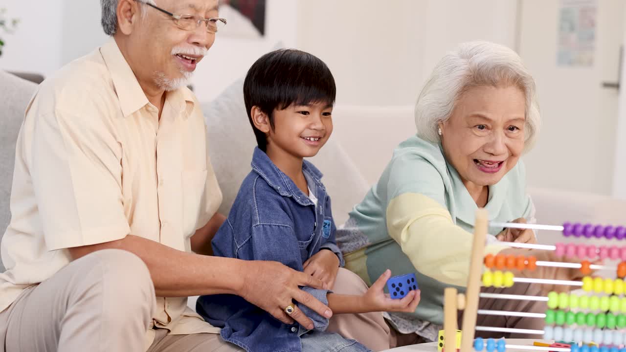 Elderly couple and young boy play dice, sharing laughter and connection in a bright room