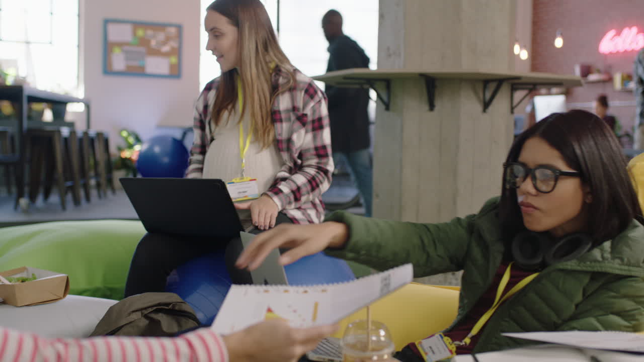 jóvenes empresarios se reúnen haciendo una lluvia de ideas líder de equipo embarazada mujer discutiendo un proyecto de trabajo en equipo compartiendo documentos con colegas colaborando en una exitosa oficina de inicio