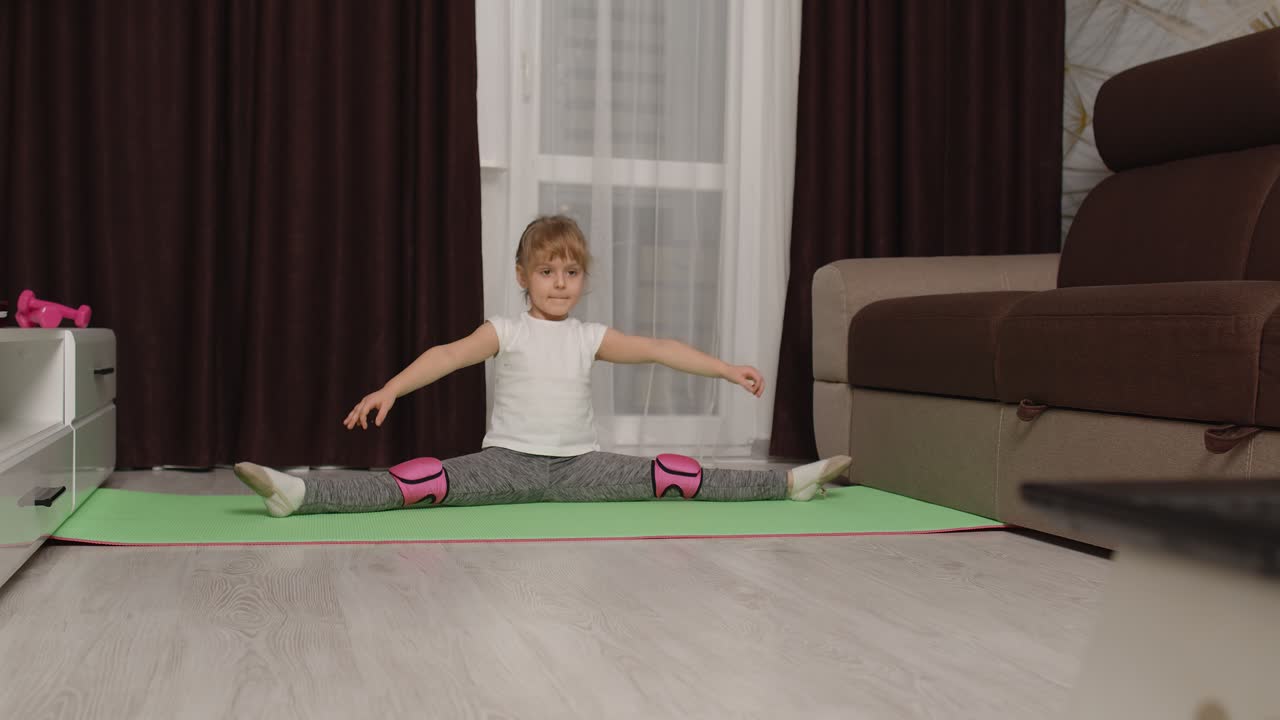 niñas viendo clases a distancia en línea con un entrenador en una computadora portátil, haciendo ejercicios de cuerda en casa