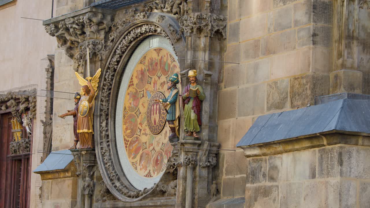 Medieval astronomical clock statues animate in daylight, camera slowly pans right, highlighting gothic details