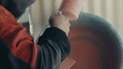 Hombre-Usando-Pistola-De-Pintura-En-Aerosol-En-Un-Taller-De-Cerámica-En-Antigua,-Guatemala