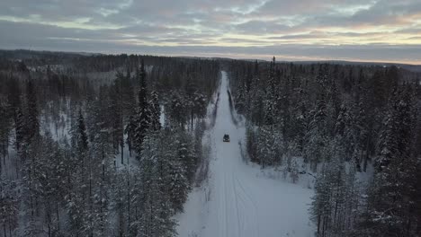 Cars-driving-through-a-snow-covered-landscape-near-Kuusamo,-Finland