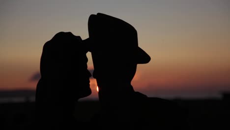 sunset timelapse in between a kissing couple (statue silhouette)