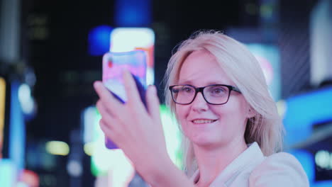 retrato de una mujer atractiva tomando fotografías de lugares de interés en times square se encuentra en el fondo