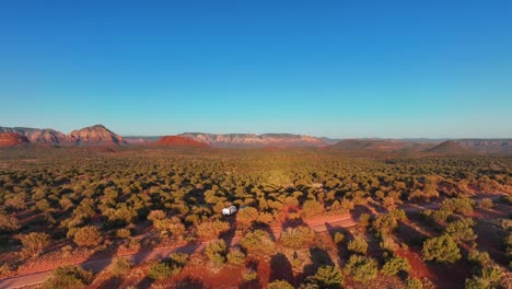 Motorhome-Parked-In-The-Red-Desert-Of-Sedona-At-Sunset-In-Arizona,-USA---aerial-pullback