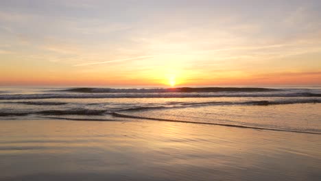 gentle sea waves in slow motion with golden sky at dawn