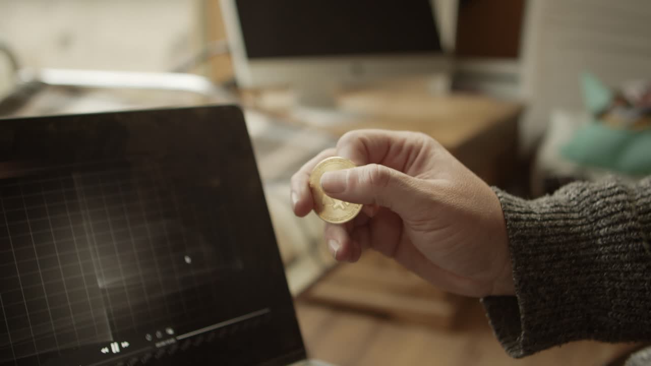 comerciante revisando el gráfico de bitcoin y sosteniendo la moneda en la mano, concepto criptográfico