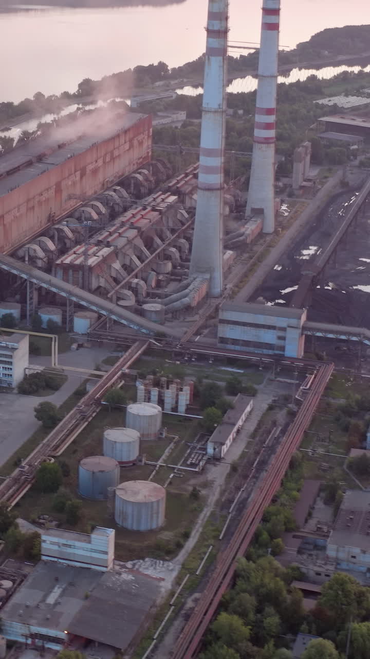 Site with high-voltage lines on the background of the road and trees at sunset. Camera motion forward. Aerial view. Vertical video