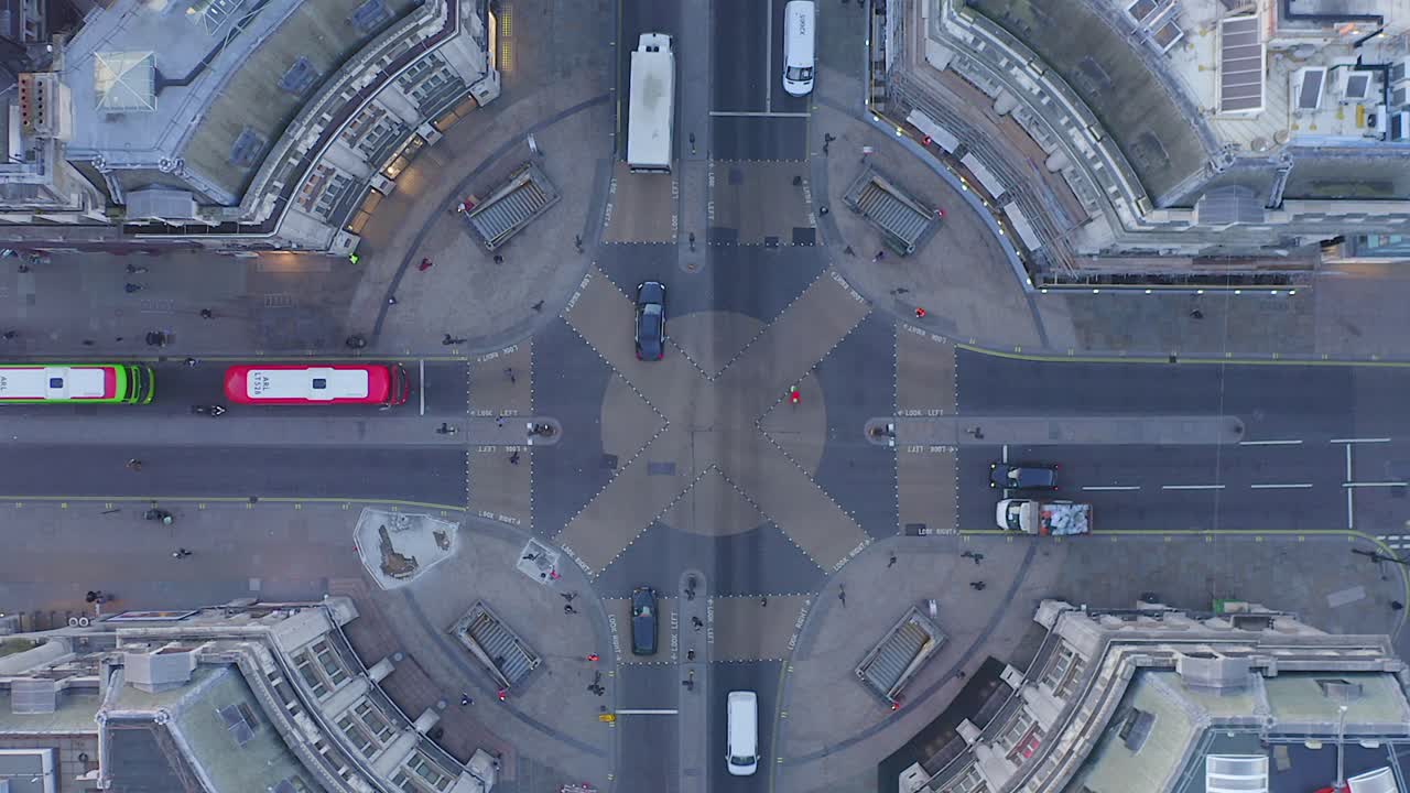 Video shows Oxford Circus in London, during the off peak hour. The video ascends quickly to show the roundabout in full.