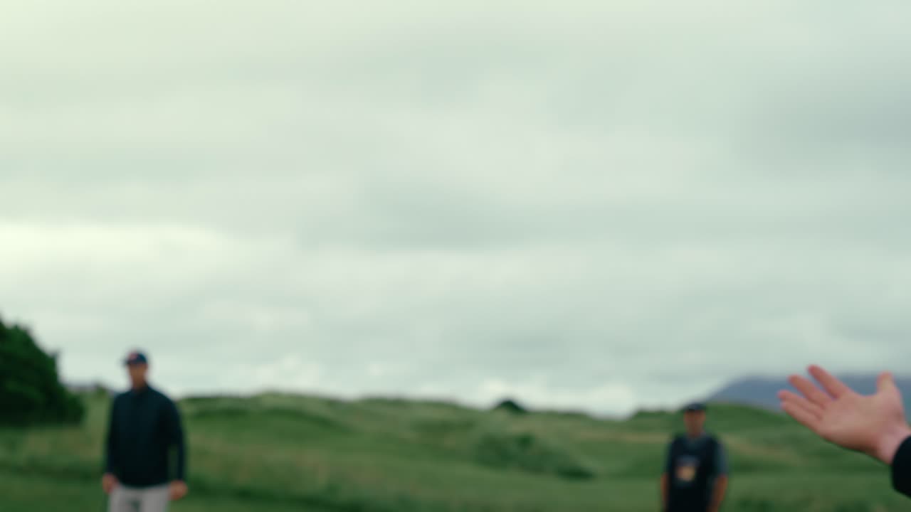 남자 골퍼가 가라앉은 후 파트너를 뛰고 아일랜드 링크스 골프장에서 푸팅 그린을 니다.