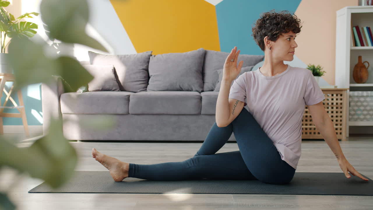 Woman practicing seated yoga twist in a living room