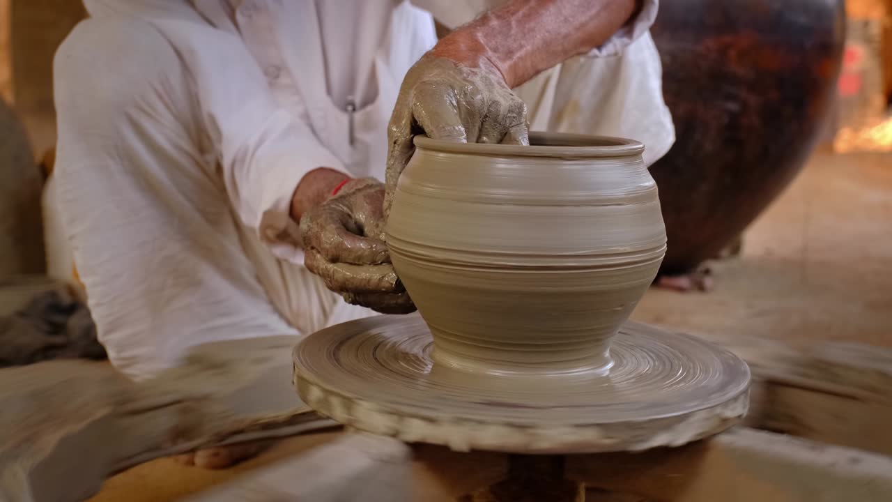 숙련된 도자기의 손은 도자기 바에 점토를 형성하고 점토 비 항아리를 조각합니다. 파그램, 우다이푸르, 라자스탄, 인도