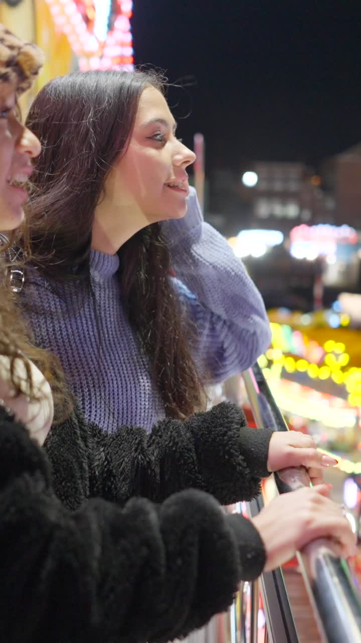 Night View of a Busy Amusement Park with Bumper Cars and People
