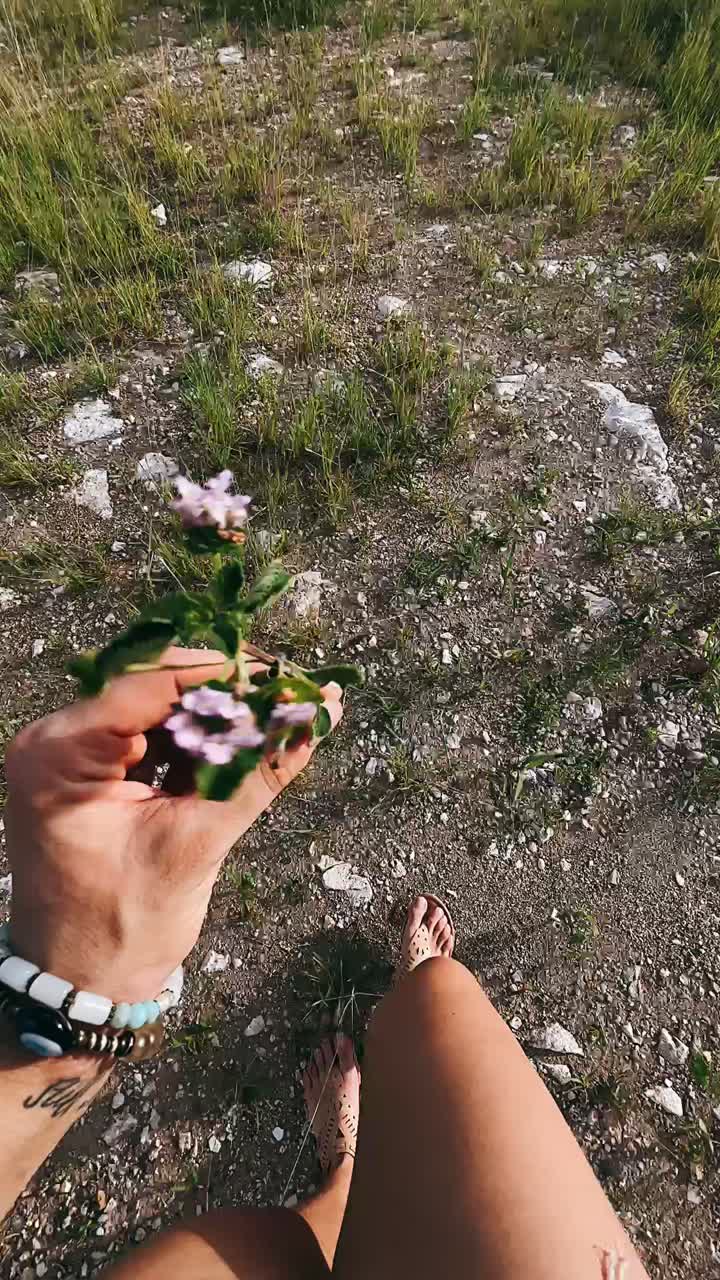 persona sosteniendo una pequeña flor en una caminata por la naturaleza