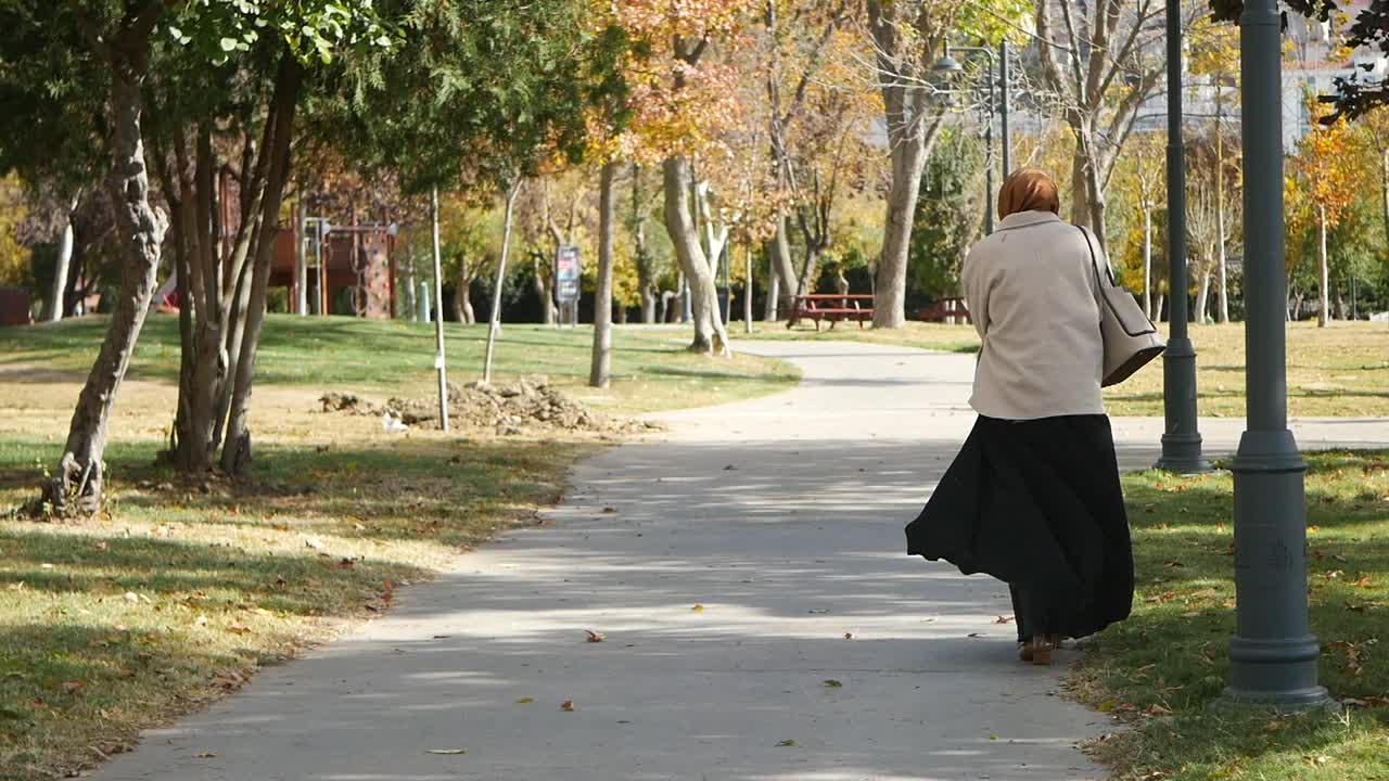 женщина в хиджабе гуляет в парке