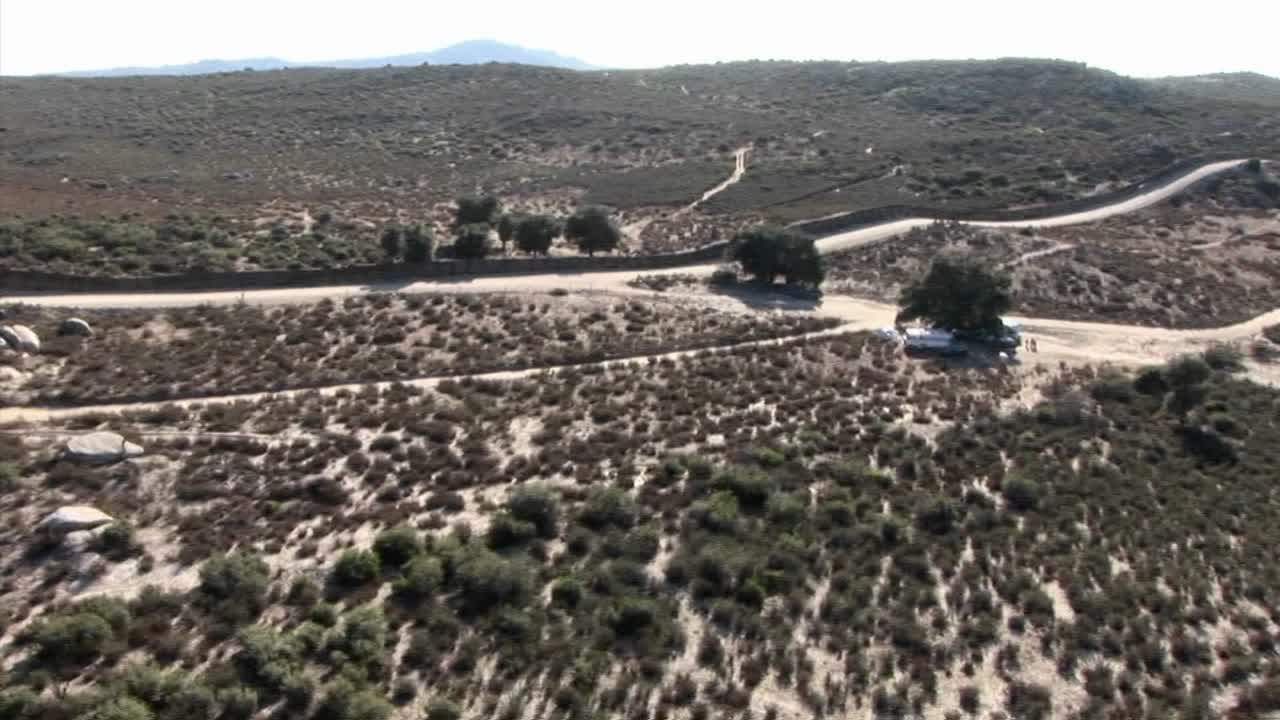 캠핑카는 길가의 나무 아래에 주차되어 있습니다.