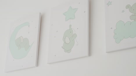cute elephant wall art with pastel stars and clouds in a soft baby room setting