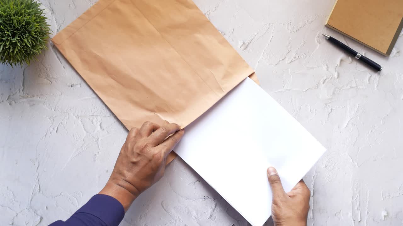 갈색 봉투 를 열고 있는 사람