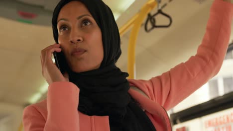 young woman wearing hijab commuting on a bus