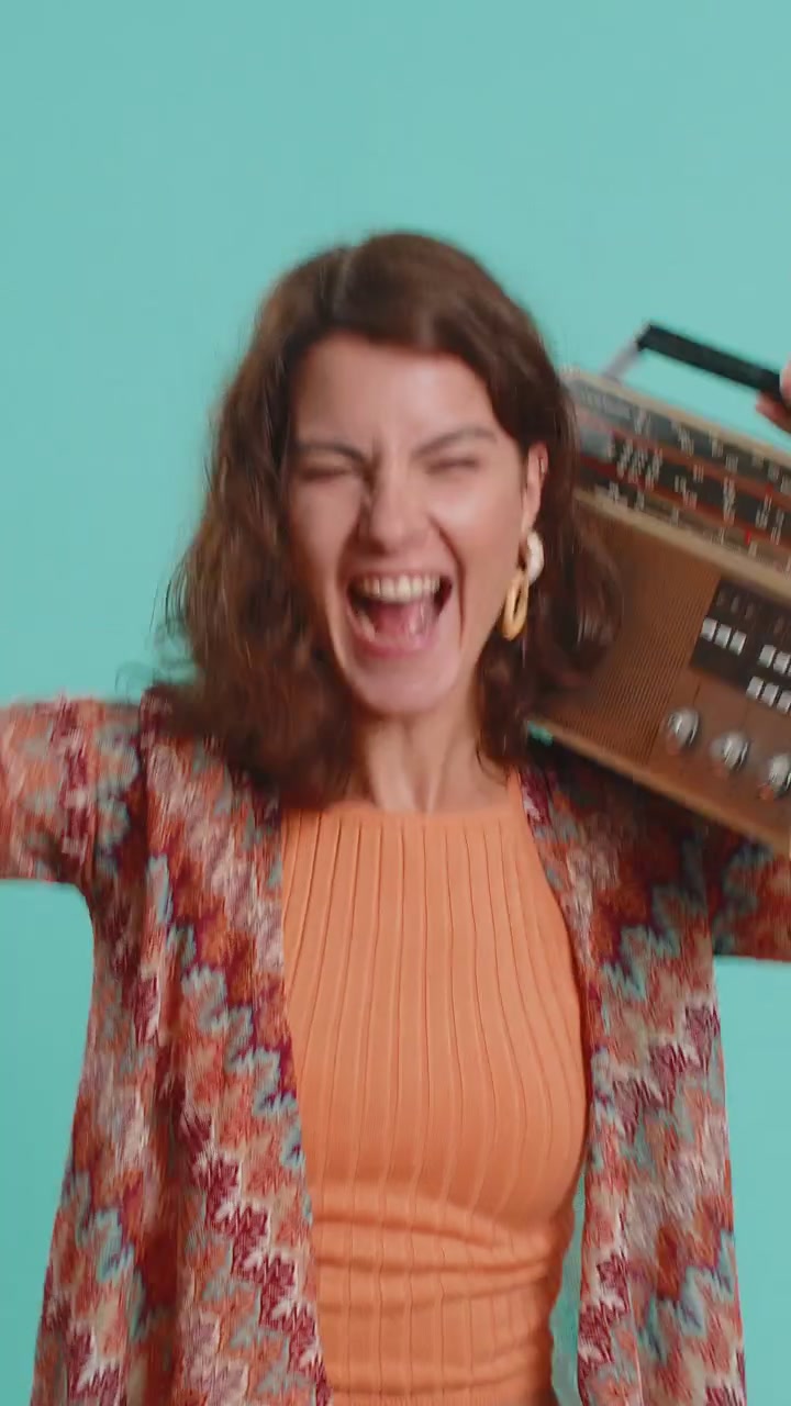 Donna che usa un giradischi retro per ascoltare musica disco ballando la sua canzone preferita divertendosi