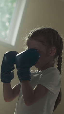 niño golpes y bloques con el instructor en el gimnasio. joven entrenador con niña pequeña hacen ejercicio de lucha en el club de boxeo en cámara lenta. escuela de artes marciales