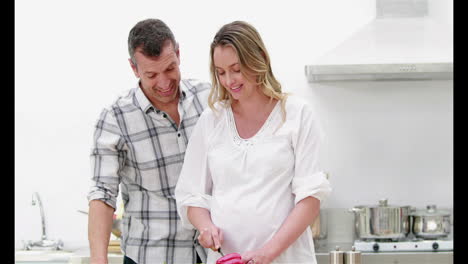 mujer embarazada haciendo una ensalada con su marido