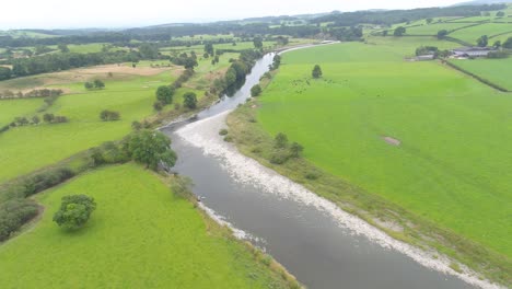 Drone-footage-at-400-feet-of-a-meandering,-slow-moving-river-in-the-rolling-hills-of-the-Lake-District,-UK