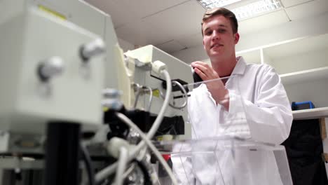 joven estudiante de ciencias mirando a través de un microscopio de alta potencia.